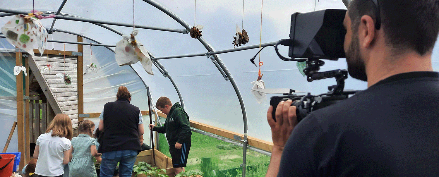 community climate action group being filmed inside greenhouse